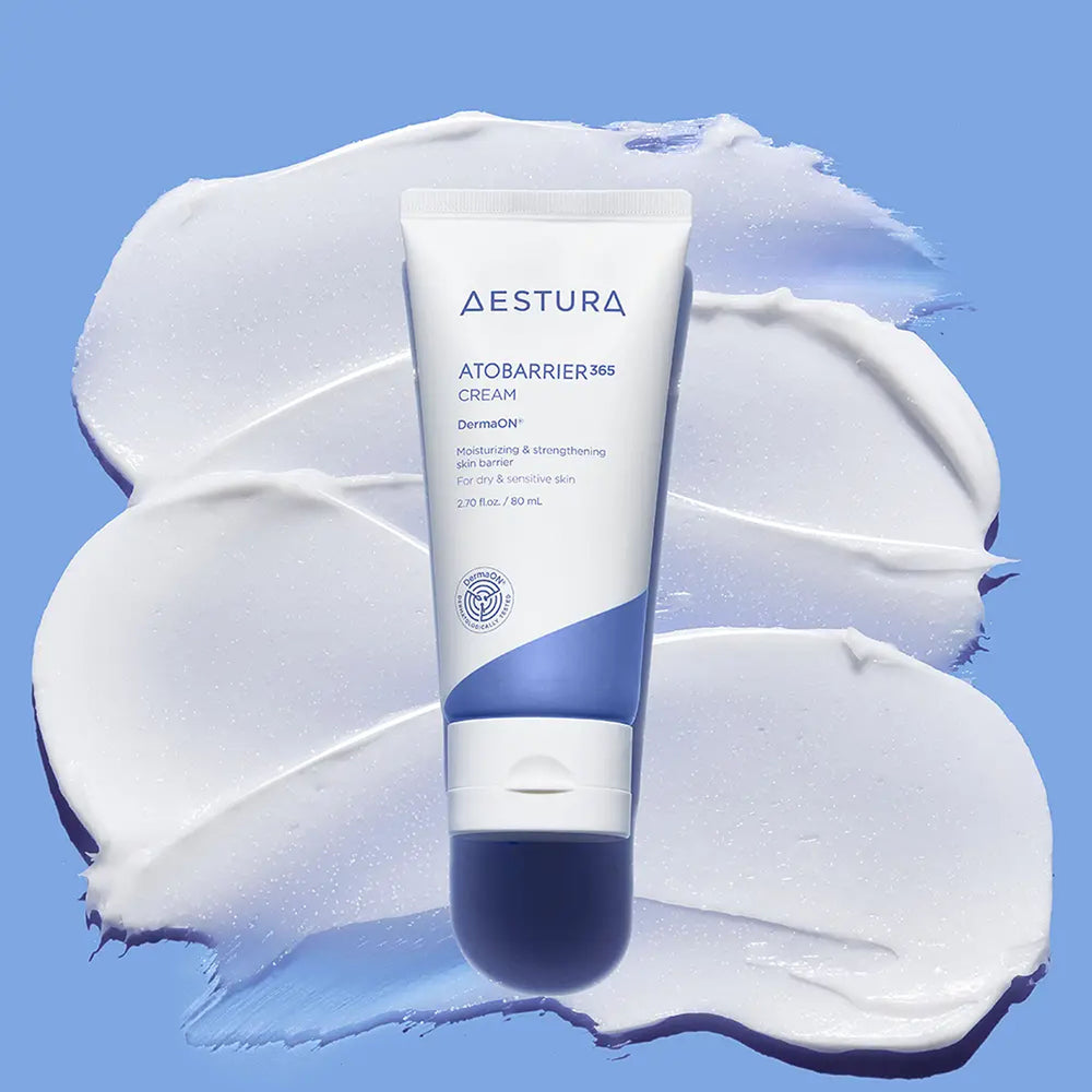 AESTURA ATOBARRIER365 CREAM 80ml tube displayed over white cream swatches on a blue background.