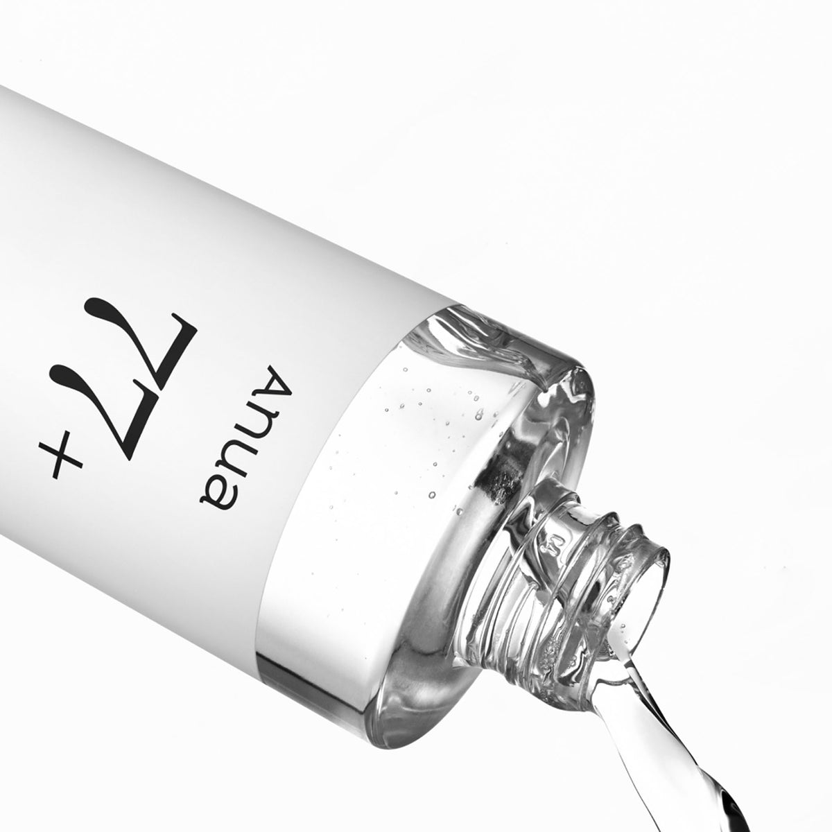 Anua Heartleaf 77 Soothing Toner bottle tilted diagonally, pouring clear liquid against a white background.