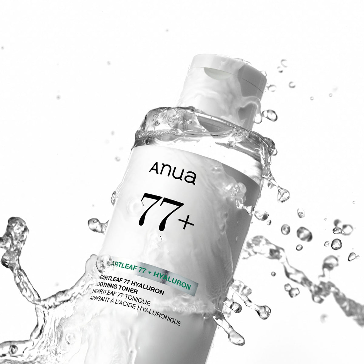 Anua Heartleaf 77 Soothing Toner bottle tilted diagonally with splashing water against a white background.